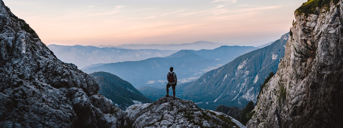 A hiker on a mountain top stares into the distance. A succession or inheritance disputes often appear as an insuperable mountain. Dr. Hosser, specialist lawyer for inheritance law, supports his clients to manage the exertions.